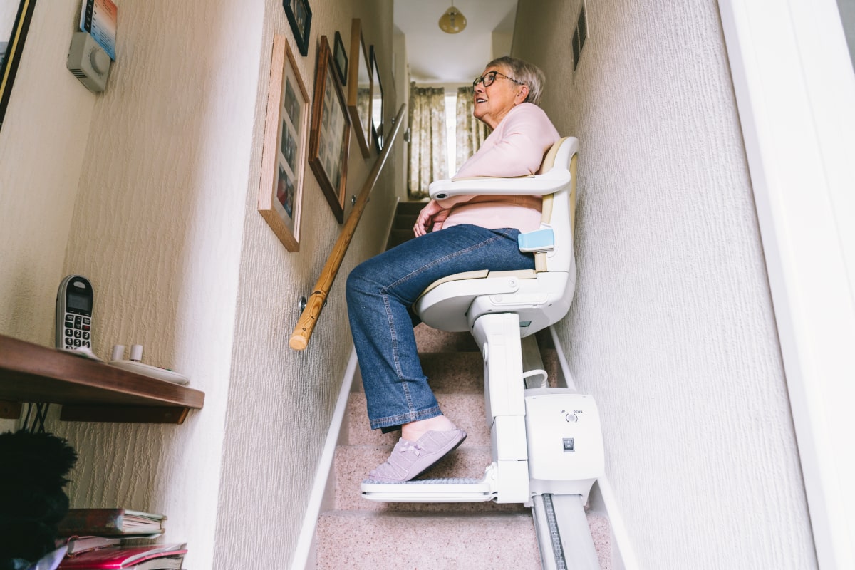 senior woman using automatic stair lift vs home elevator